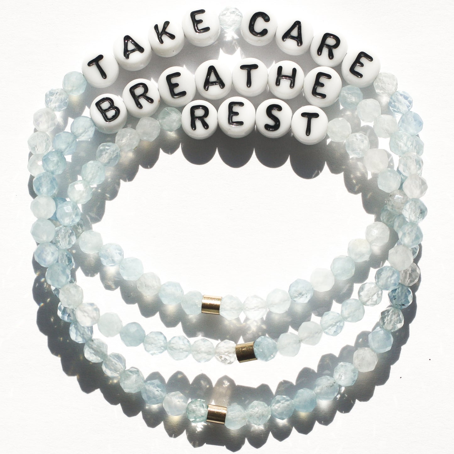 TAKE CARE, REST, and BREATHE bracelets in aquamarine